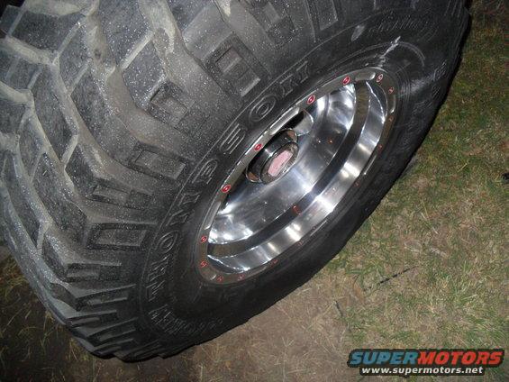 Tire with aggressive tread pattern and chrome rim with red lug nuts