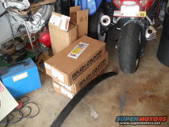 motorcycle rear end with boxes and tools in garage