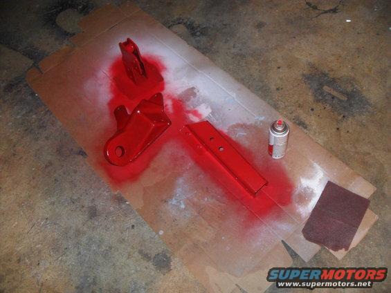 Red painted metal parts with spray can and sandpaper