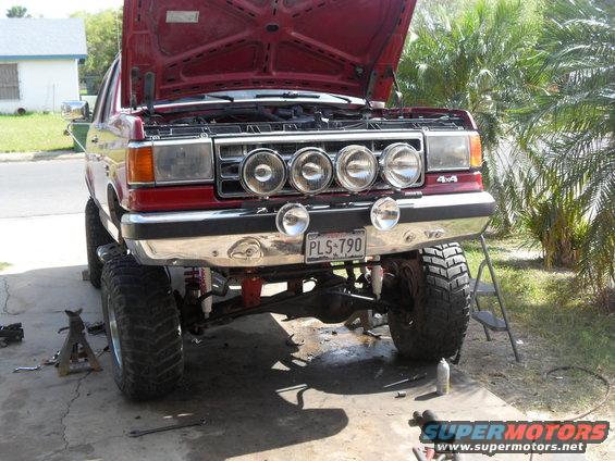 1990 Ford Bronco with hood open, lifted suspension, and auxiliary lights