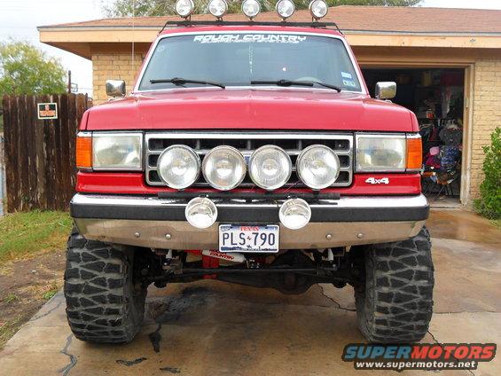 Red 4x4 SUV with roof lights and front light bar. License plate says PLS 790