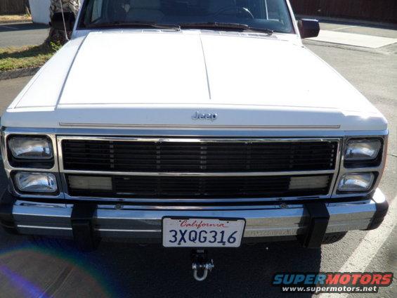 White 1994 Jeep Cherokee front view, chrome grille, California license plate 3XQG316