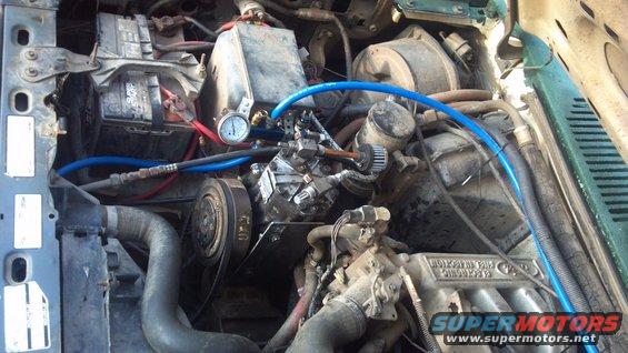 Engine bay with AC compressor and gauge