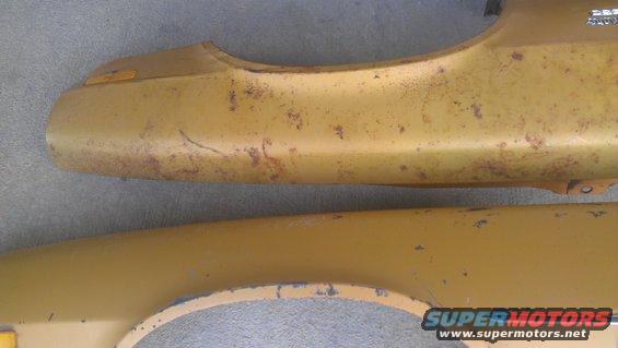 Yellow fender parts with rust and paint chips