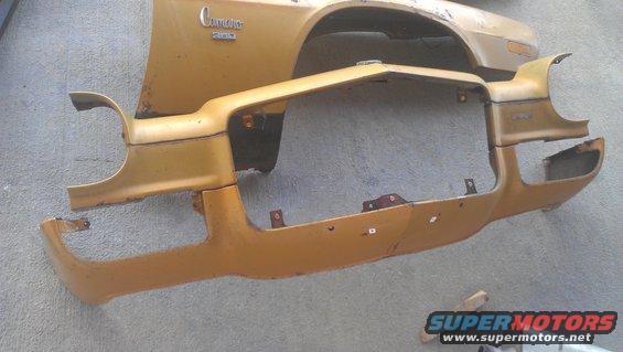 Gold 1973 Chevrolet Camaro fender and bumper assembly, showing rust and damage