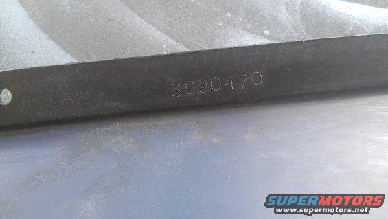 Black metal part with stamped number 3990470
