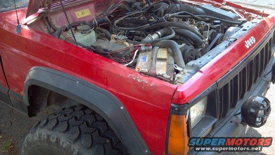Red 1995 Jeep Cherokee engine bay with hood open