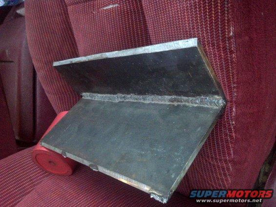 welded metal bracket on red patterned car seat