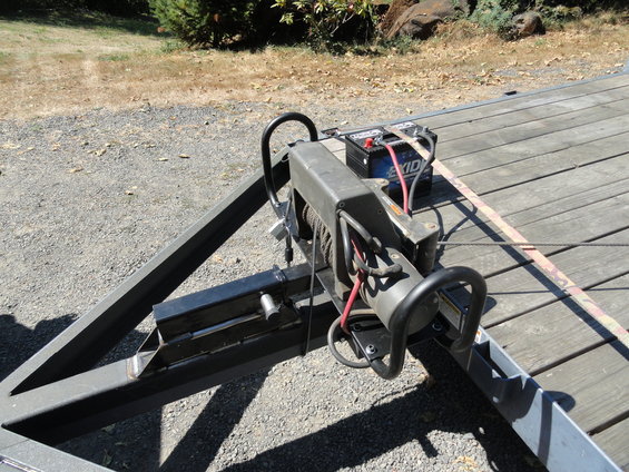 Winch and Exide battery on a wooden trailer deck, with metal frame