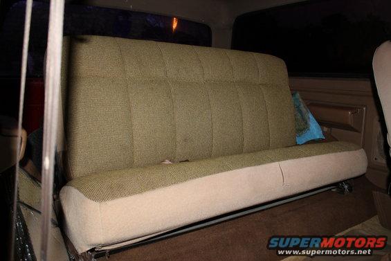 1990 Ford Bronco rear bench seat with patterned green fabric and beige lower cushion