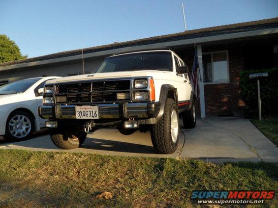 White 1993 Jeep Cherokee with a red stripe, parked in a driveway