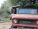 1966 International Scout 800 - Two International Scouts are parked outdoors, with one man removing the hardtop from the front vehicle.