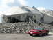 2003 Mercury Marauder - A red Ford Mustang coupe is parked outside a unique building with a geodesic dome.