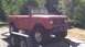 1966 International Scout 800 - This red convertible SUV is on a trailer, ready for transport.