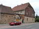 2003 Mercury Marauder - A red Ford Mustang is parked on a cobblestone street next to historic European-style buildings.