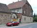 2003 Mercury Marauder - A red coupe is parked on a cobblestone street in front of a historic building.