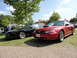 2003 Mercury Marauder - Red Ford Mustang parked next to a black car under a sunny sky.