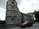 2003 Mercury Marauder - A red coupe is parked on a cobblestone path in front of a large stone castle under a cloudy sky.