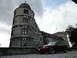 2003 Mercury Marauder - A red coupe from the early 2000s is parked in front of a historic castle under a cloudy sky.