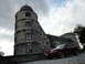 2003 Mercury Marauder - A red coupe is parked in front of a historic castle under a cloudy sky.