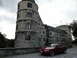2003 Mercury Marauder - A red Ford Mustang is parked in front of a historic stone castle under a cloudy sky.