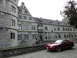 2003 Mercury Marauder - A red coupe is parked on a cobblestone path in front of a historic stone building.