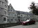 2003 Mercury Marauder - A red coupe with a distinctive hood scoop is parked on a cobblestone street in front of a historic stone building.