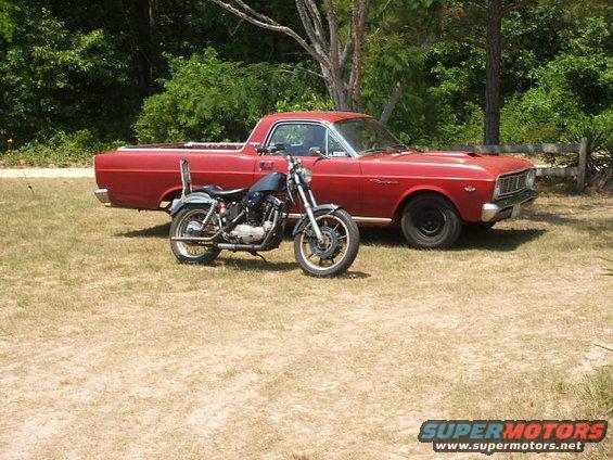 Red 1966 Ford Ranchero parked next to a motorcycle on a grassy area