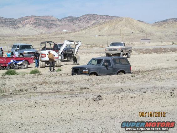Dark gray Ford Bronco stuck in mud, front end submerged