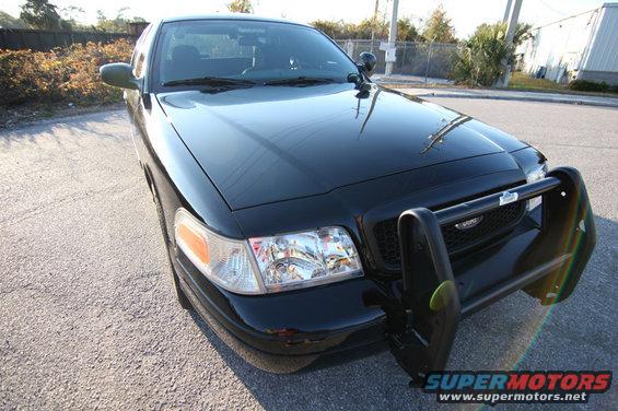 Black Ford Crown Victoria police car with push bumper, front view