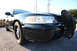 2004 Ford Crown Victoria - A black 2004 Ford Crown Victoria Police Interceptor is parked on a street, showing its front end and a push bumper.