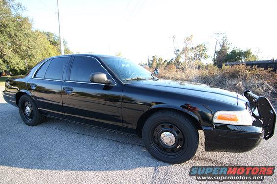 Black 2004 Ford Crown Victoria police car, front quarter view with push bar