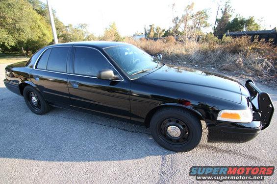 2004 Ford Crown Victoria sedan with push bar, black paint, tinted windows, and steel wheels