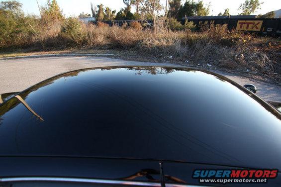 Black car roof reflecting trees and a train car with TTX logo