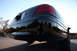 2004 Ford Crown Victoria - The rear of a black sedan is shown from a low angle against a clear sky.
