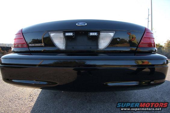 Black 2004 Ford Crown Victoria Police Interceptor rear view with Ford emblem and police lights