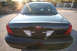 2004 Ford Crown Victoria - Rear view of a black 2004 Ford Crown Victoria, its iconic Ford badge and auxiliary police lights.