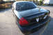 2004 Ford Crown Victoria - Rear view of a black Ford Crown Victoria sedan parked on asphalt.