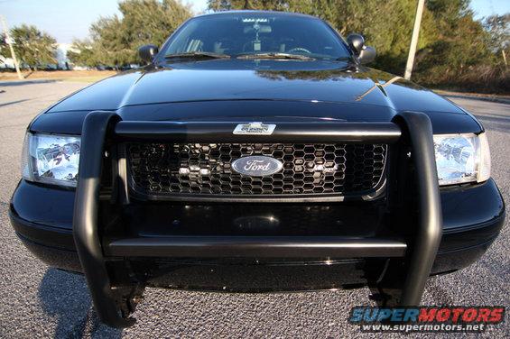Front view of a black 2004 Ford Crown Victoria with a push bar and honeycomb grille