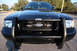 2004 Ford Crown Victoria - This black 2004 Ford Crown Victoria is shown from the front, a protective push bar and a distinctive honeycomb grille.