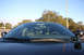 2004 Ford Crown Victoria - Front view of a black 2004 Ford Crown Victoria, showing the interior and a light bar mounted above the windshield.