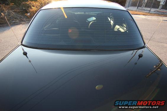Rear of black 2004 Ford Crown Victoria with tinted windows and two antennas