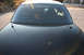2004 Ford Crown Victoria - Rear view of a black 2004 Ford Crown Victoria sedan, showing its tinted rear window and dual antennas.