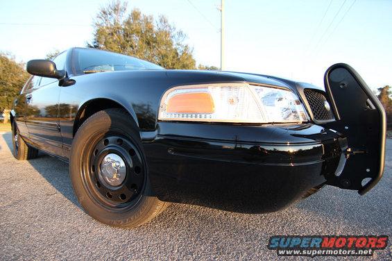 Black 2004 Ford Crown Victoria with a push bar, front quarter view, parked on asphalt
