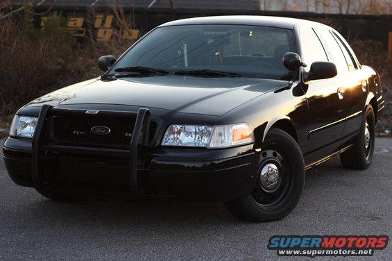 Black 2004 Ford Crown Victoria with a push bar and steel wheels, viewed from the front-left
