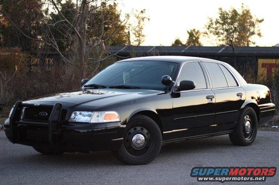 Black 2004 Ford Crown Victoria police car with a push bumper, parked on asphalt