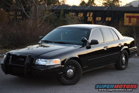 Black 2004 Ford Crown Victoria Police Interceptor with a push bumper parked on pavement