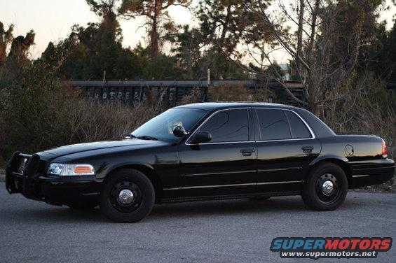 Black 2004 Ford Crown Victoria sedan with a push bar, parked on asphalt