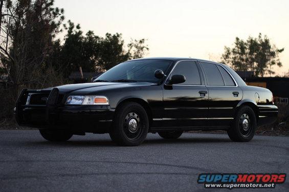 Black 2004 Ford Crown Victoria P71 police car with a push bar, parked on asphalt