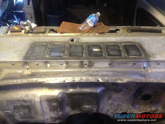 Welded metal panel with square cutouts and a water bottle on top